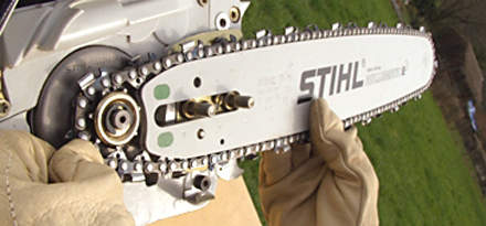 : 步骤7：拿起装好的锯链和导板，把锯链绕在链轮上。在安装螺母上滑动导板到孔里。